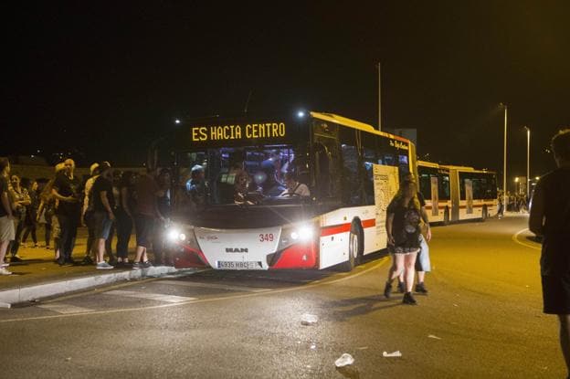 Dos pasajeros descienden de un autobús de EMTUSA, en las inmediaciones de una parada. 