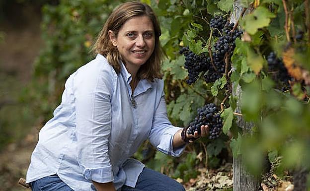 Beatriz Pérez ojea unas uvas en un viñedo situado frente a la bodega.