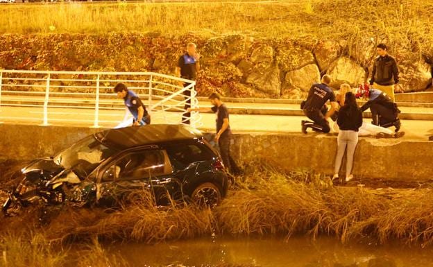 Agentes de la Policía Local de Gijón atienden al herido tras el accidente.