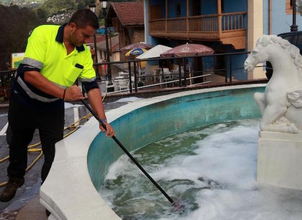 Un operario limpia la fuente con espuma. 