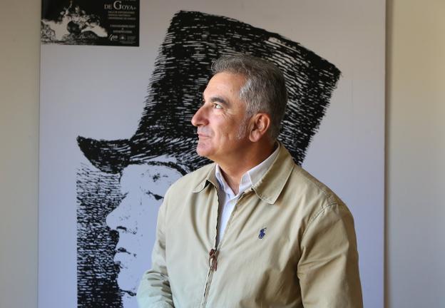 Fermín Rodríguez, ante un cartel de una exposición de Goya que exhibe en su despacho. 