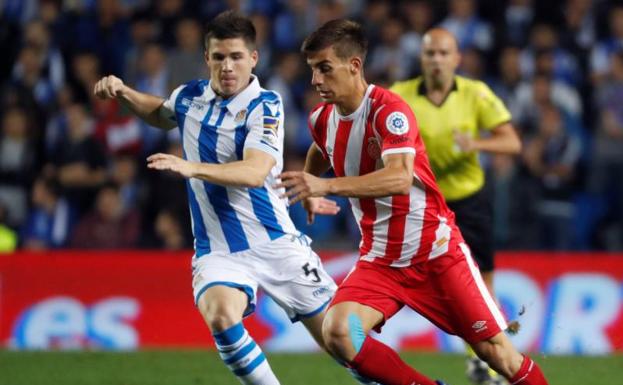 El centrocampista de la Real Sociedad Igor Zubeldia (i), pelea un balón con el centrocampista del Girona Pere Pons.