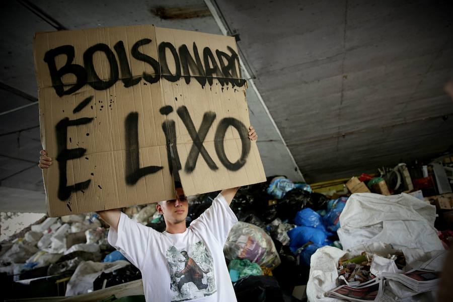 Un joven protesta con una pancarta en la que se lee 'Bolsonaro basura'.