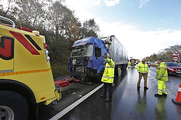 Tres operarios, ante el camión accidentado. 