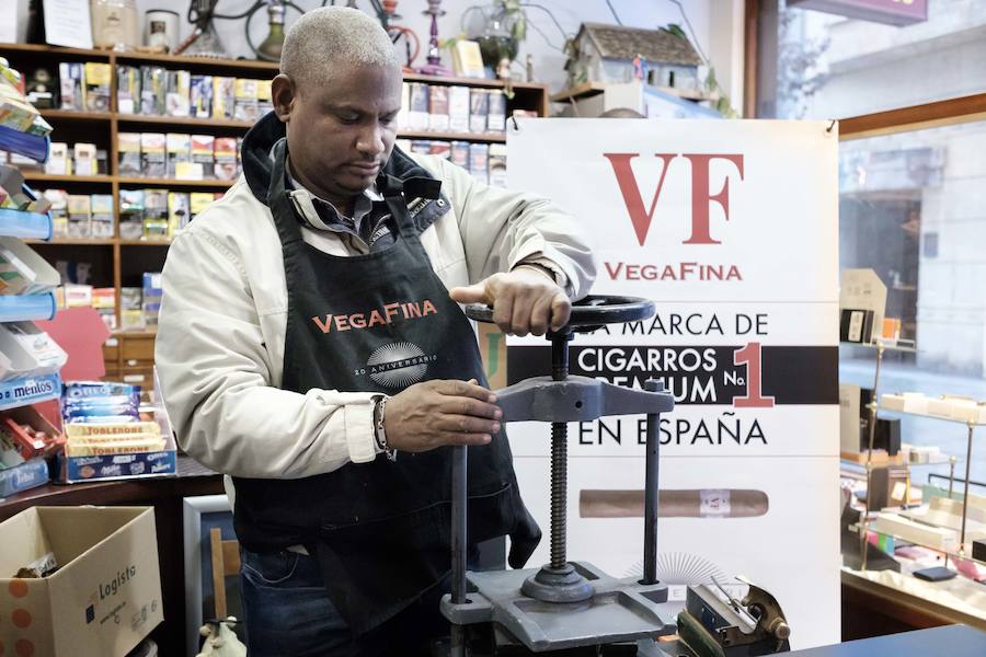 El maestro torcedor dominicano Roberto Mota sorprende a los clientes del estanco de Corrida, en Gijón, con una exhibición de torcido de puros