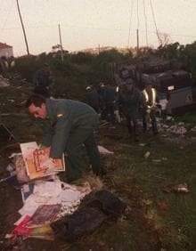 Imagen secundaria 2 - 1. Labores de retirada de restos en el lugar del accidente, en la localidad llanisca de Buelna | 2. Un agente de la Guardia Civil recoge material escolar desperdigado por el prao | 3. Decenas de coronas y ramos de flores inundaron el cementerio de Colombres. 