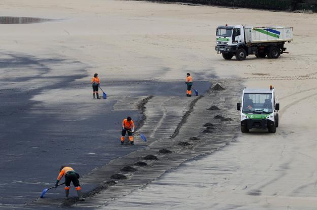 Trabajos de limpieza en la playa tras uno de los afloramientos de carbón que hubo a principios de este año. 