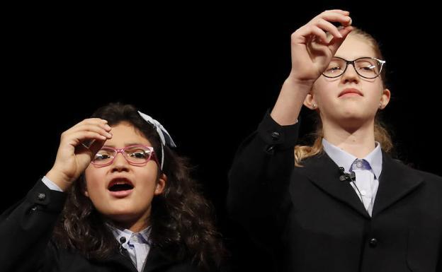 Dos niñas de San Ildefonso cantan uno de los premios. 