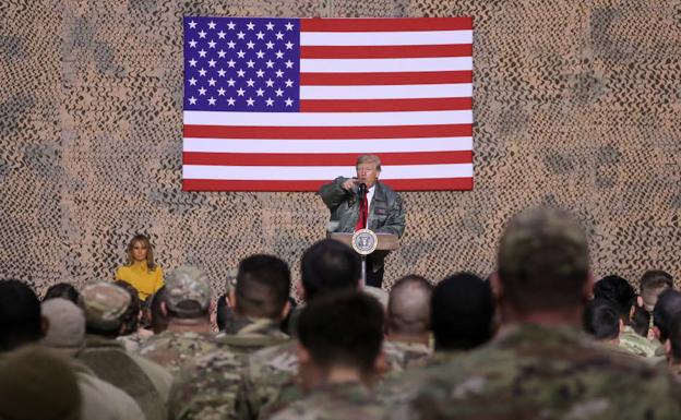 El presidente Donald Trump, con la primera dama Melania Trump, hace declaraciones a las tropas de los Estados Unidos en una visita inesperada a la base aérea de Al Asad, Irak.