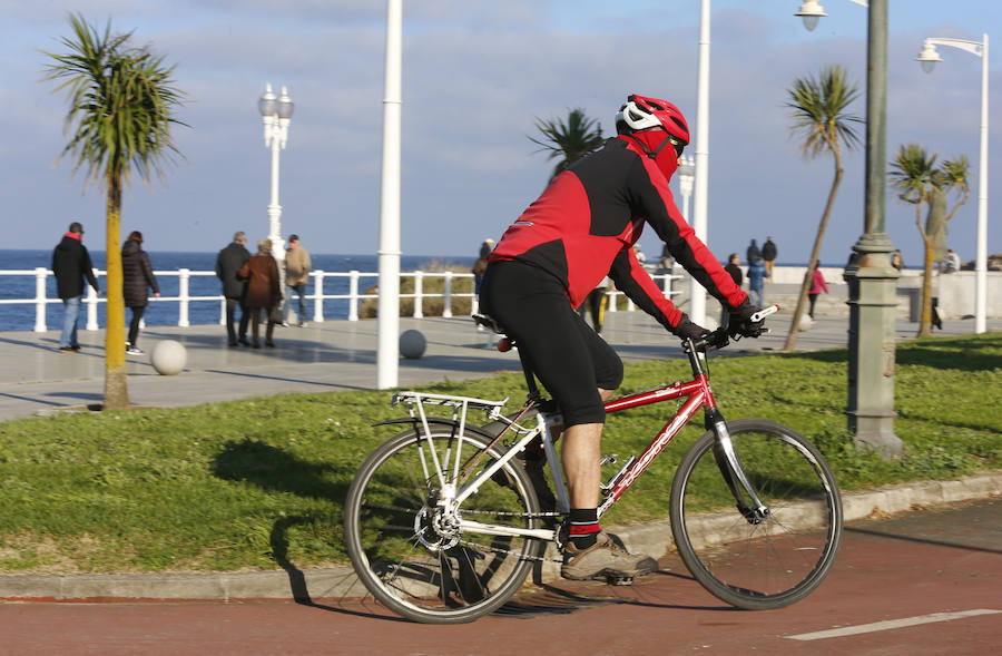 A pesar del frío, los gijoneses no han desperdiciado la oportunidad de disfrutar de la ausencia de nubes, ya sea paseando, en bicicleta o corriendo.