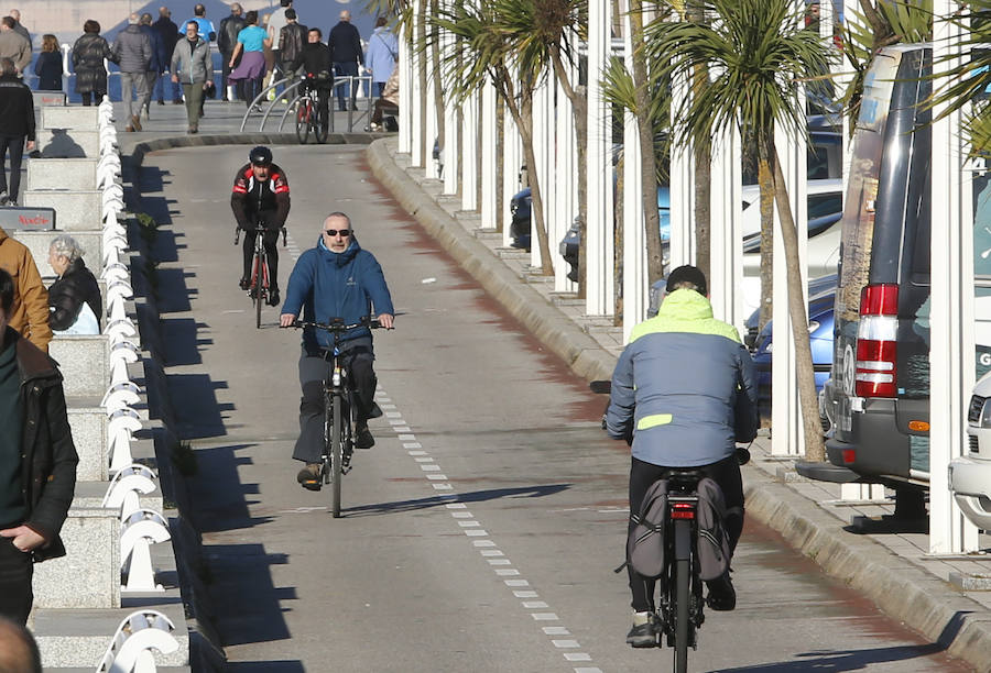 A pesar del frío, los gijoneses no han desperdiciado la oportunidad de disfrutar de la ausencia de nubes, ya sea paseando, en bicicleta o corriendo.