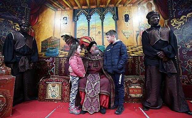 Los pequeños Andrea y Julio Somoano cuentan sus peticiones al Príncipe Aliatar bajo la mirada de sus dos ayudantes. 