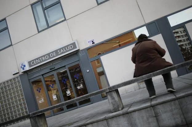 Una mujer, sentada en un banco frente al centro de salud de La Felguera. 