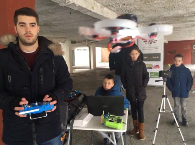David Álvarez pilota un dron ante varios escolares en La Felguera. 