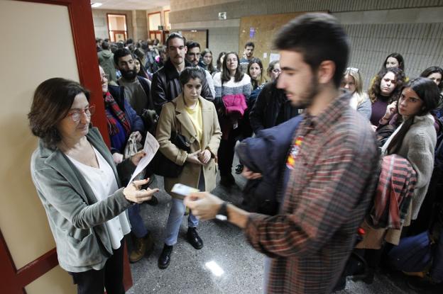 Uno de los aspirantes entrega su identificación para poder acceder a una de las aulas donde se celebraron los exámenes. 