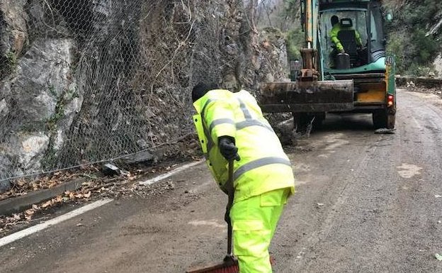 Varios operarios, despejando la carretera