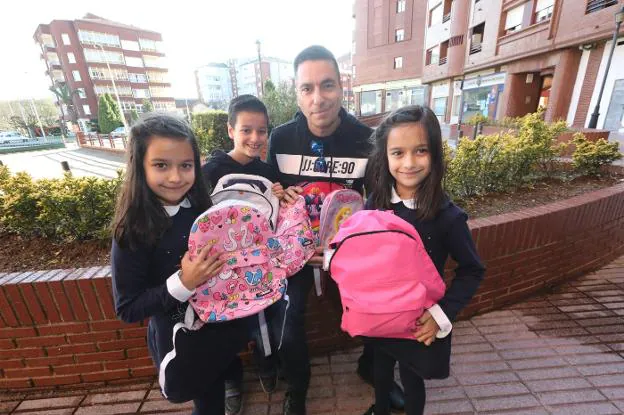 Jorge Coronado con sus tres hijos y las mochilas solidarias con las que ellos contribuirán. 
