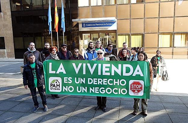 Una veintena de manifestantes ayer, con esta pancarta, ante la Consejería de Servicios y Derechos Sociales. 