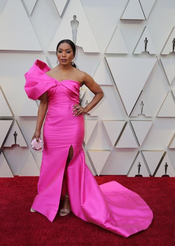 Angela Bassett apostó por un traje de color fucsia de Reem Acra que llevaba una lazada en el escote demasiado exagerada.