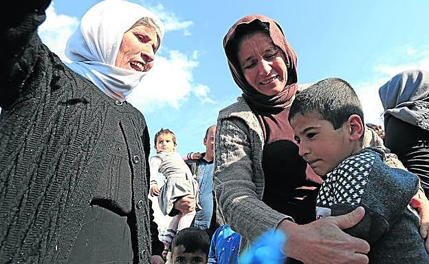 Un niño yazidí es recibido por sus familiares tras ser rescatado por las fuerzas kurdas que combaten en Siria al Estado Islámico.