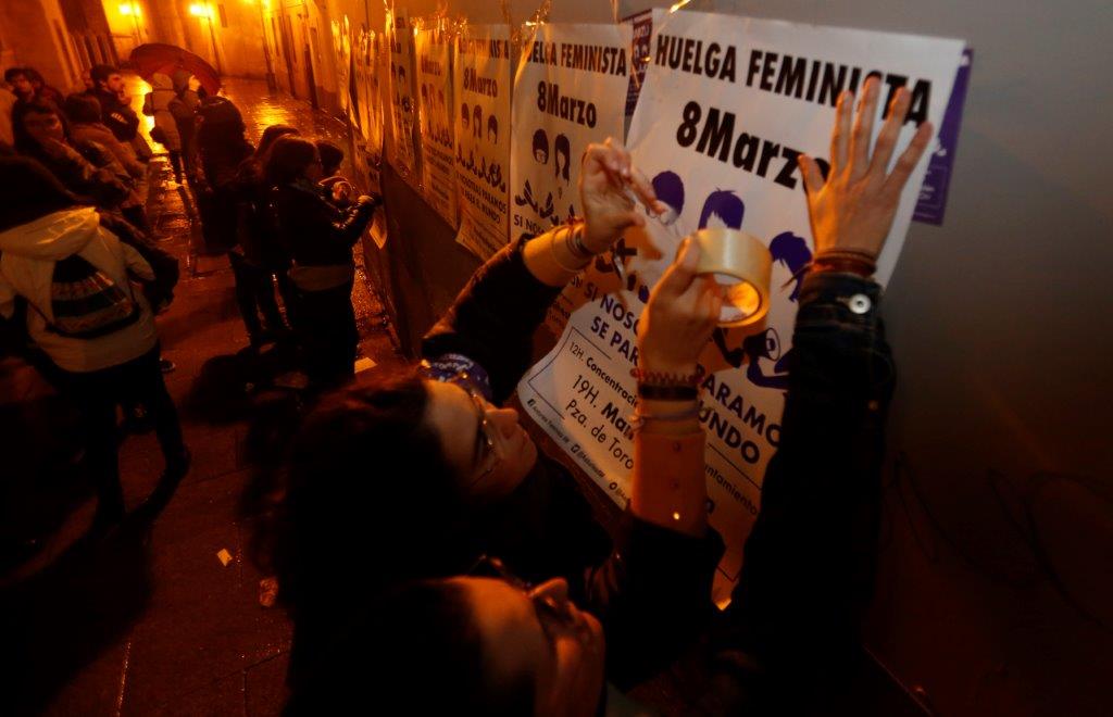 Un veintena de personas comenzó la jornada de huelga general feminista con una pega de carteles convocando a la manifestación de esta tarde en Gijón