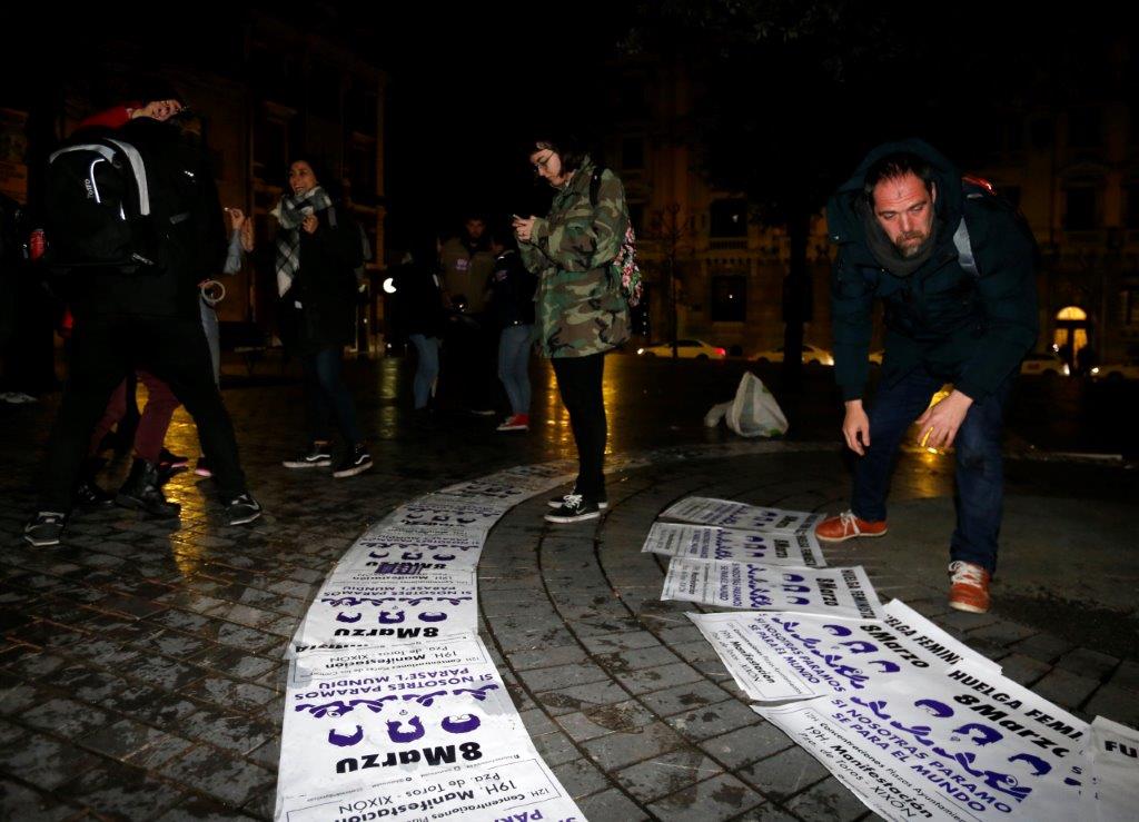 Un veintena de personas comenzó la jornada de huelga general feminista con una pega de carteles convocando a la manifestación de esta tarde en Gijón