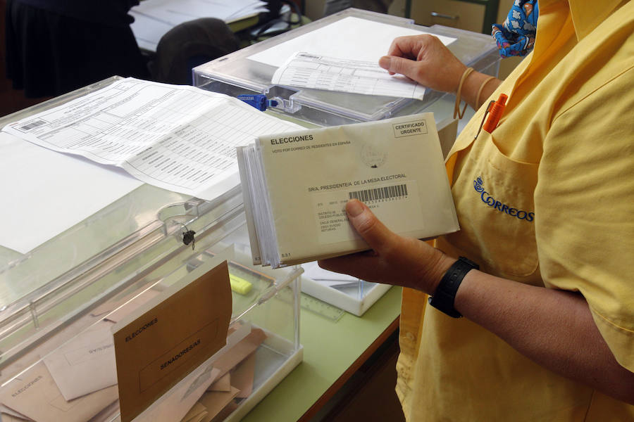 Introduciendo el voto por correo en una urna electoral de Oviedo.