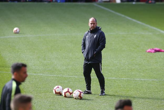 José Alberto López observa a sus futbolistas mientras realizan los primeros ejercicios del entrenamiento que dirigió en El Molinón ante cerca de 200 personas.