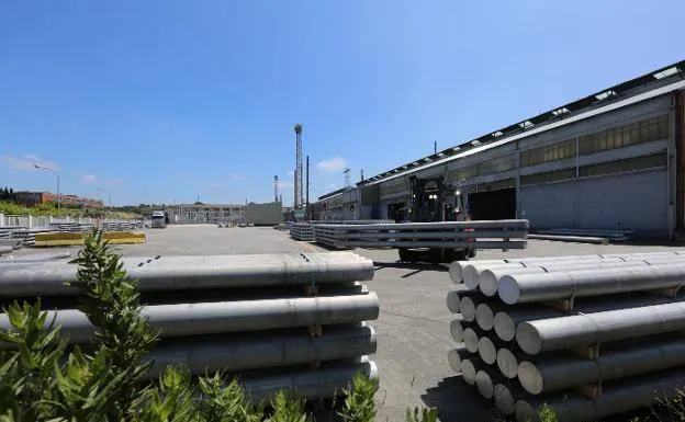 Un operario transporta varias piezas en la explanada de la fábrica de Alcoa en Avilés.