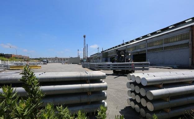 Un operario transporta varias piezas en la explanada de la fábrica de Alcoa en Avilés.