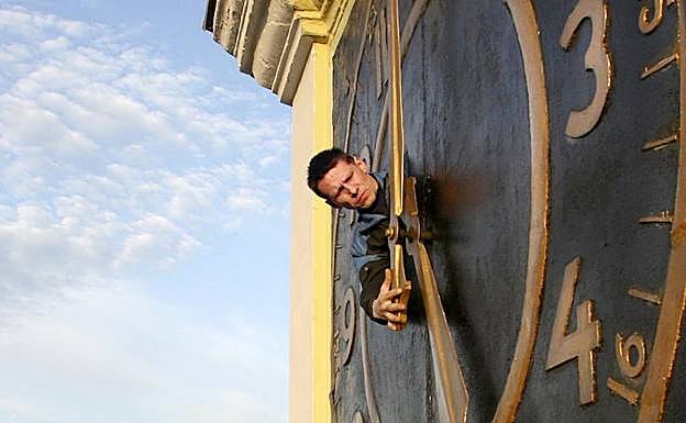 Un empleado municipal retrasa una hora un gigantesco reloj de manecillas instalado en un edificio de Minsk. 