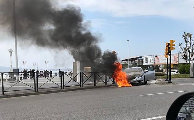El vehículo, ardiendo en el puente del Piles en Gijón. 