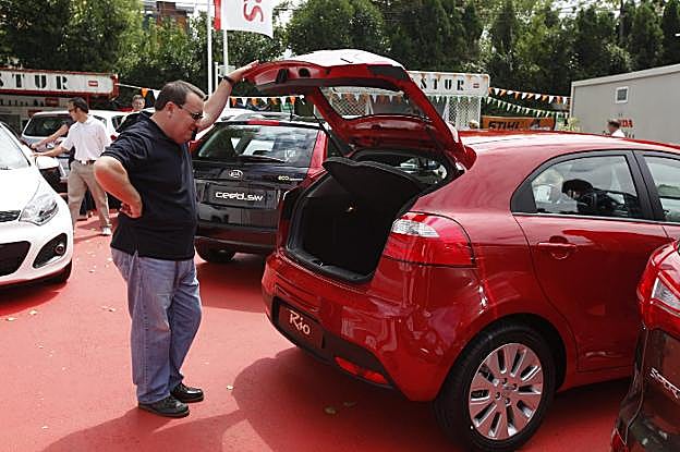 Un usuario observa un coche en un stand de la Feria. 