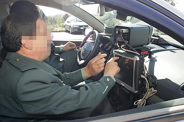 Dos agentes manejan un dispositivo de radar móvil en la red de carreteras de Asturias. 