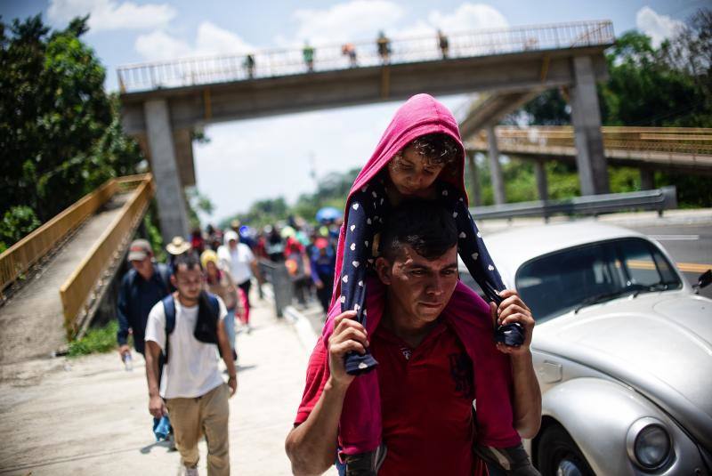 Los migrantes centroamericanos que se dirigen a los Estados Unidos caminan en caravana a lo largo de la carretera entre Metapa y Tapachula en México