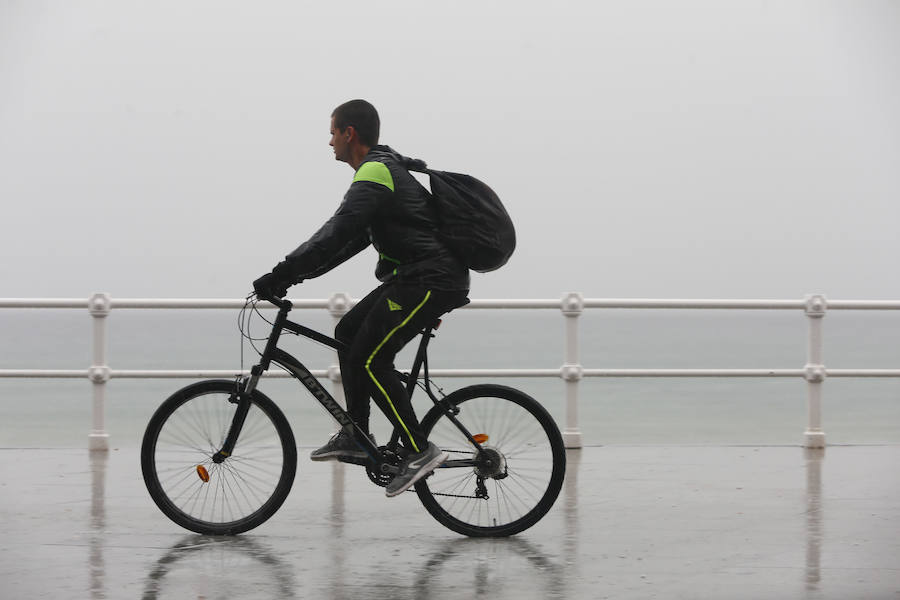 Aunque la mañana había librado del agua, las lluvias hicieron su aparición en Gijón por la tarde, con intensidad y acompañadas de tormenta