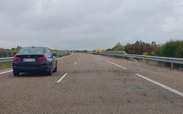 Un vehículo circula por la izquierda para evitar los baches. 