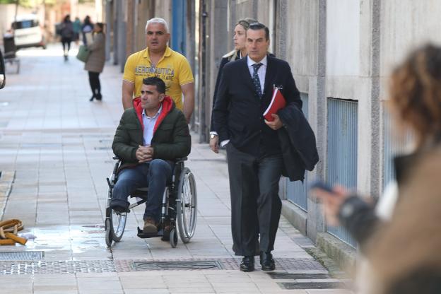 Omar López, en silla de ruedas, acompañado de su esposa y su letrado, Víctor Tartiere. 