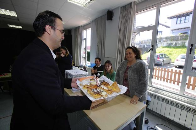 Jesús Bordás lleva una bandeja de pasteles con velas a Mayka Fernández, en Colombres. 