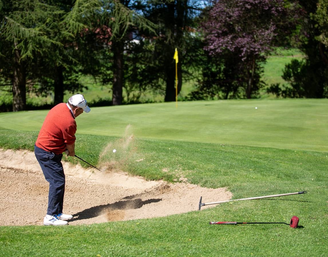 Un golfista trata de salir de un bunker.