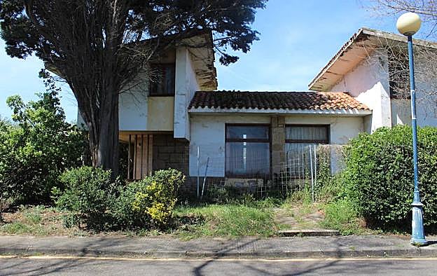 Muchas viviendas están ahora valladas por seguridad y rodeadas de maleza.