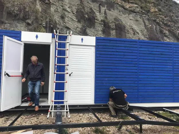 Los operarios trabajan en la instalación del pabellón. 