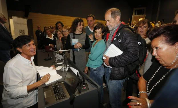 Carlos López-Otín firma ejemplares de su nuevo libro a los asistentes que colmaron la sala de conferencias de la Antigua Escuela de Comercio. 