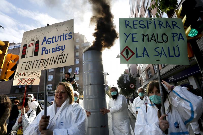 Un centenar de militantes y simpatizantes de Podemos-Equo han protagonizado un pasacalles contra la contaminación en la zona oeste de Gijón. Los participantes, ataviados con trajes de aislamiento y mascarillas, han llamado la atención de los viandantes con una puesta en escena teatral y portando una gran chimenea que no paraba de humear. Yolanda Huergo, Daniel Ripa y Lorena Gil estuvieron entre los participantes en esta 'performance'. 
