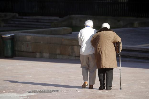 Una pareja de personas mayores disfruta de un paseo por las calles de Oviedo. 