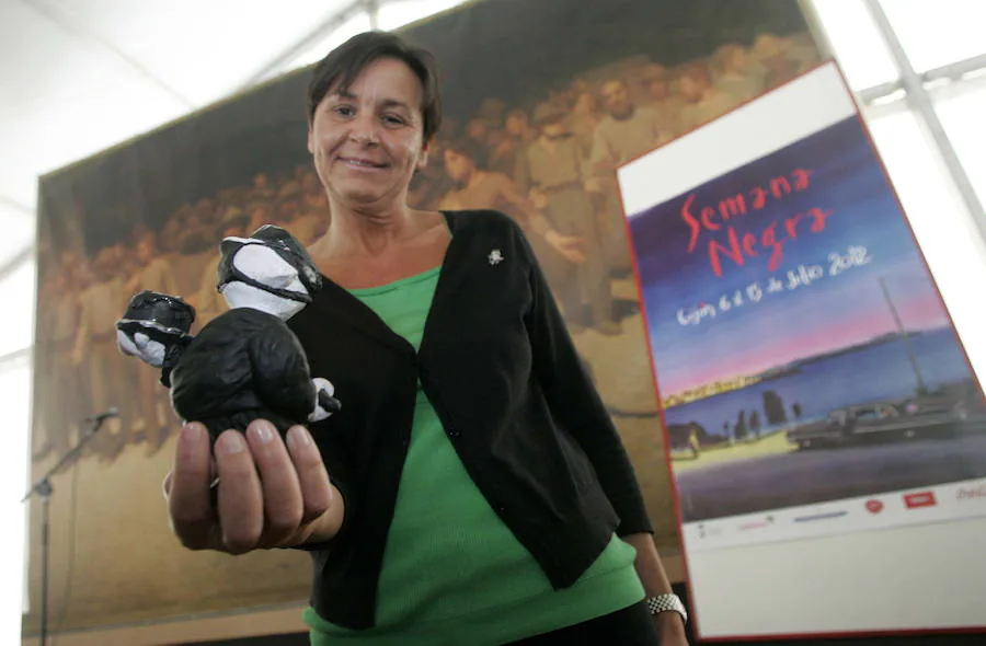 La alcaldesa sostiene en su mano a 'Rufo', la mascota de la Semana Negra, que este año se disfraza de cirujano con un bisturí para partir la tarta del 25 aniversario.