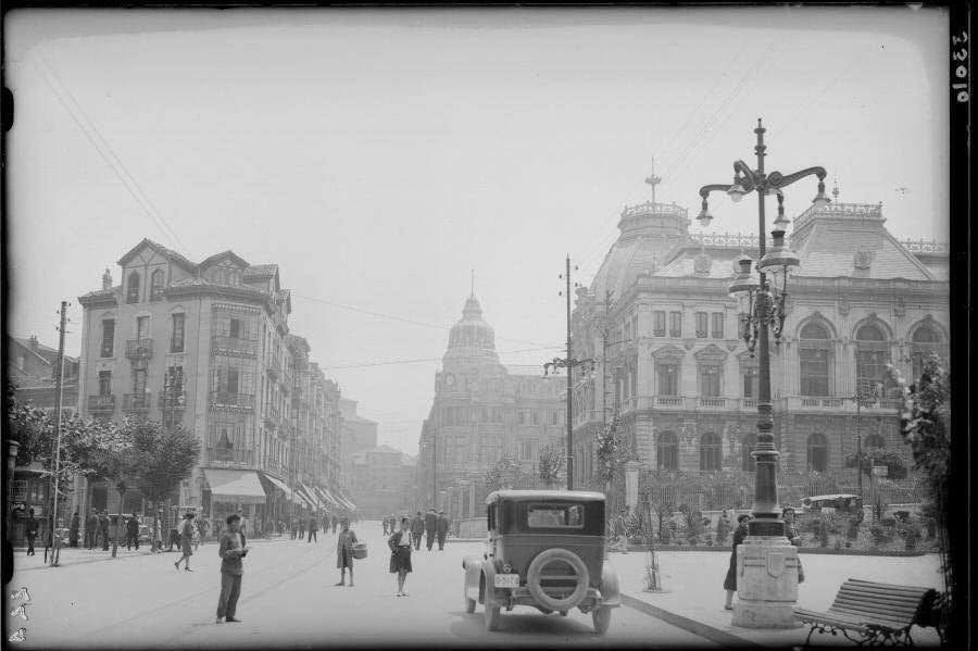 Un coche en la calle Fruela, con el edificio de la Diputación y el Banco Herrero al fondo.