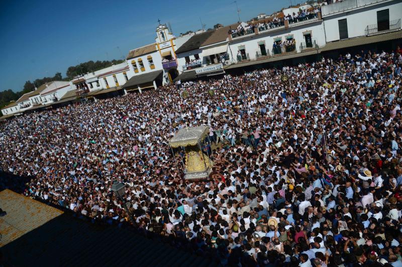 Multitudinaria y larga procesión de la Virgen del Rocío en Almonte (Huelva). En torno a las 2.49 horas de este Lunes de Pentecostés tuvo lugar el 'salto de la reja' y la imagen salió de la ermita para comenzar la tradicional procesión a hombros de los almonteños que se ha prolongado hasta las 12.31 horas, cuando ha vuelto a su Santuario. En su recorrido ante las 124 hermandades participantes, la Virgen ha vestido traje y manto con más de 2.000 piezas bordadas en oro fino en el taller de Fernando Calderón.