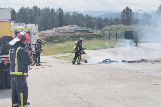 Los bomberos sofocan los rescoldos del incendio en el acuartelamiento asturiano. 