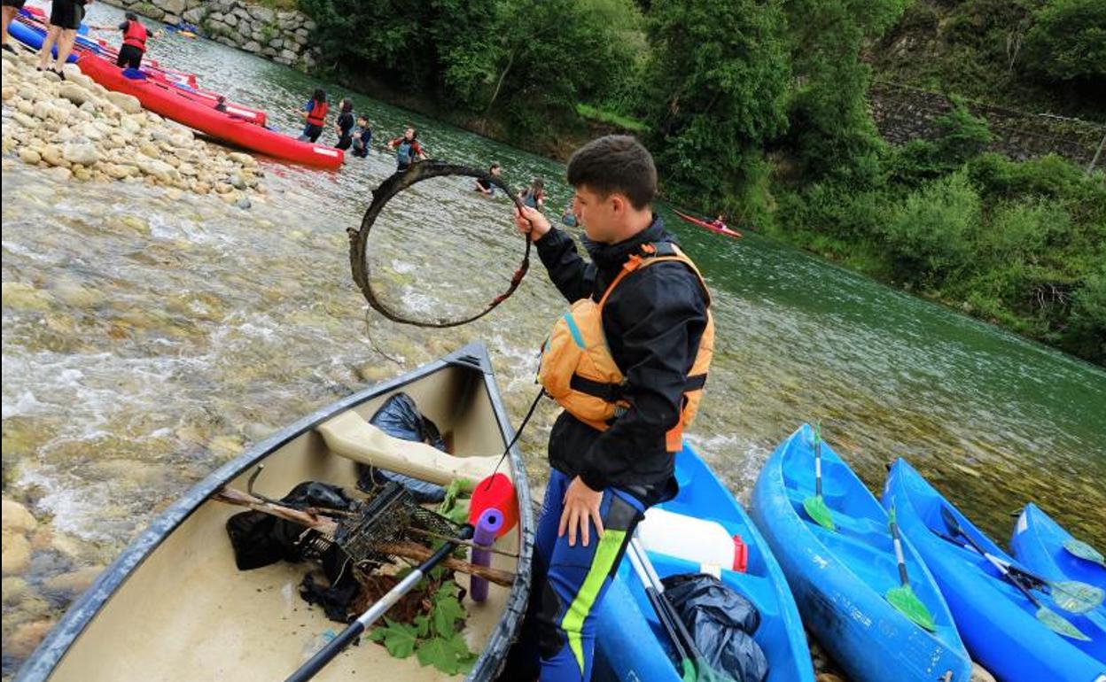 Uno de los alumnos retira resiudos del río.